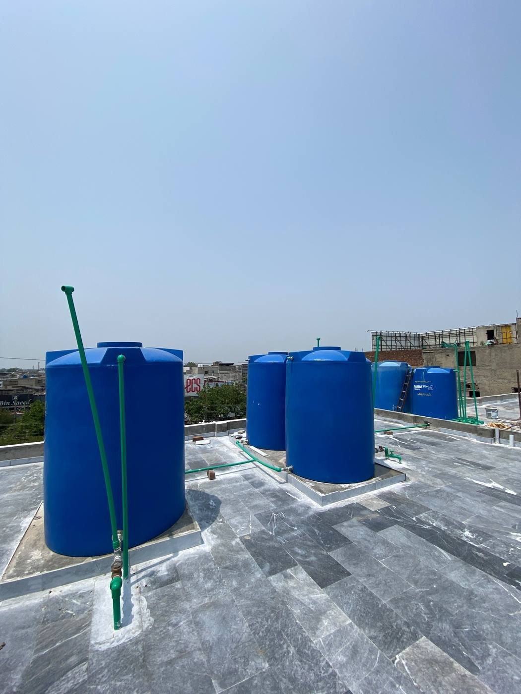 Rooftop water storage tanks feeding the building's filtration system at Maple Girls' Residence, Lahore